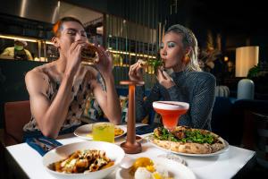 two women sitting at a table eating food at Public House Hotel - Sukhumvit 31 in Bangkok