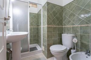 Un baño con inodoro, lavabo y ducha. en BLife Faya private rooms, en Faro