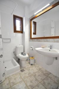 a bathroom with a toilet and a sink and a tub at Zennova #43, Pirgadikia Sky & Sea Home in Pyrgadikia