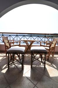 a couple of chairs and a table on a balcony at Zennova #43, Pirgadikia Sky & Sea Home in Pyrgadikia