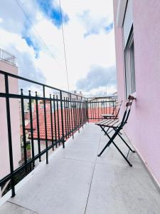a bench sitting on the balcony of a pink building at You will love it, in Vracar in Belgrade