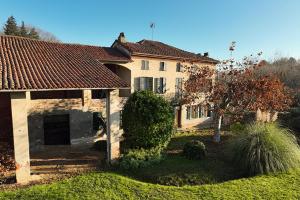 une grande maison avec un toit rouge dans une cour dans l'établissement Antica Casa Santa Maria Giardino, à Pomaro Monferrato