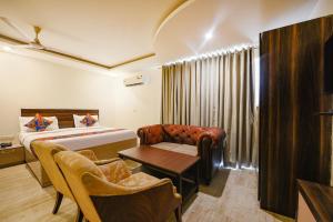 Habitación de hotel con cama, mesa y sillas en International Embassy Suites en Nueva Delhi