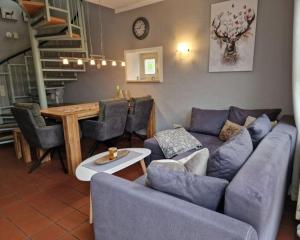 a living room with a blue couch and a table at Gemütliches Ferienhaus mit Kamin und eigenem Garten in bayerischem Feriendorf in Zandt