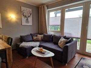 a living room with a couch and a table at Gemütliches Ferienhaus mit Kamin und eigenem Garten in bayerischem Feriendorf in Zandt