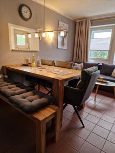 a kitchen with a wooden table and a couch at Gemütliches Ferienhaus mit Kamin und eigenem Garten in bayerischem Feriendorf in Zandt