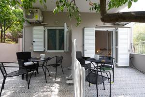 d'une terrasse avec des tables et des chaises noires et une fenêtre. dans l'établissement Sea Villa, à Akrogiali