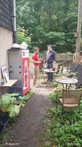 two people standing in a patio with a drink machine at Zum stillen Himmelbett in Niederwiesa