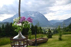 a vase of flowers in a field with a mountain at Glampingbus Lindwurm in Irdning