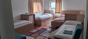 una stanza con tre letti e una sedia di Hotel Irish a Bihać