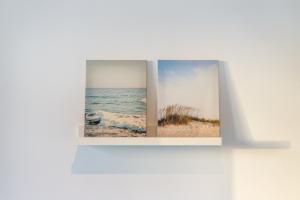 Dos fotografías de una playa y el océano en una pared. en BLife Faya private rooms, en Faro 32 fotos más