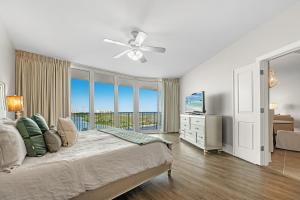 a bedroom with a bed with a ceiling fan at Caribe 409D in Orange Beach