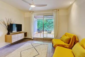 Saint-PaulにあるLe petit Lux du Lagon - La Saline les Bainsのリビングルーム(黄色のソファ、テレビ付)