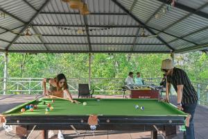 a man and a woman playing a game of pool at Saj In The Forest, Pench National Park in Seonī