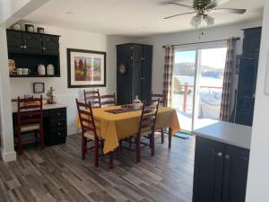 a kitchen with a table and chairs and a dining room at Hatchet Harbour Vacation Home in Herring Neck