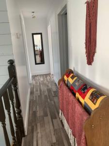 a room with a staircase with a couch and a mirror at Hatchet Harbour Vacation Home in Herring Neck