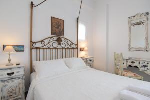 a white bedroom with a large bed with white sheets at Villa Areto in Kamares