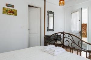 a bedroom with a bed with three towels on it at Villa Areto in Kamares