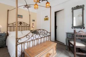 a bedroom with a canopy bed with a desk and a mirror at Villa Areto in Kamares