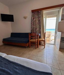 a bedroom with a couch and a table and a kitchen at Stegna Sea & Sun in Archangelos