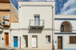 a white building with a balcony on it at Casa Vacanze Riflessi sul mare in Calasetta