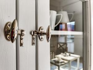 a white door with a handle and a mirror at Alte Fischfabrik Lauterbach "MehrZeit am Bodden" in Lauterbach