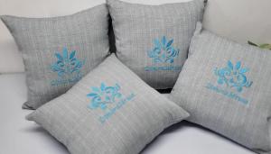 a group of four pillows with a blue logo on them at Dimora Idrusa in Otranto