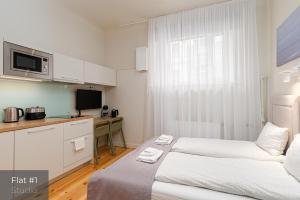 um quarto de hotel com duas camas e uma cozinha em Dandelion Apartments Stabu em Riga