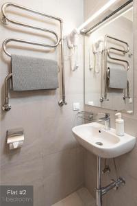 een badkamer met een wastafel en een spiegel bij Dandelion Apartments Stabu in Rīga
