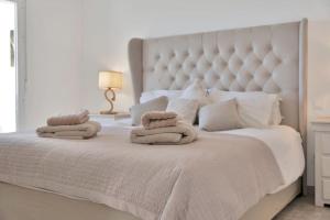 ein Schlafzimmer mit einem großen weißen Bett mit Handtüchern darauf in der Unterkunft Elegante dúplex con increíbles vistas al mar Mijas - CASCADA DE RIVIERA C2 in Sitio de Calahonda + 37 Fotos