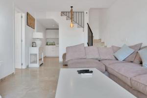 ein Wohnzimmer mit Sofa und Tisch in der Unterkunft Elegante dúplex con increíbles vistas al mar Mijas - CASCADA DE RIVIERA C2 in Sitio de Calahonda