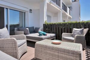 eine Terrasse mit Korbstühlen, einem Sofa und einem Tisch in der Unterkunft Elegante dúplex con increíbles vistas al mar Mijas - CASCADA DE RIVIERA C2 in Sitio de Calahonda