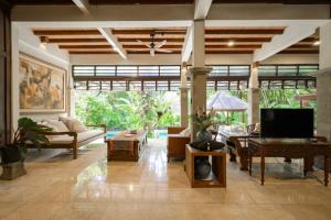 a living room with a couch and a tv at The Lavana Ziza Living And Villas Seminyak in Kerobokan