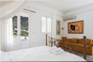a bedroom with a bed and a couch and a window at Villa Areto in Kamares