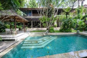 a swimming pool in front of a house at The Lavana Ziza Living And Villas Seminyak in Kerobokan