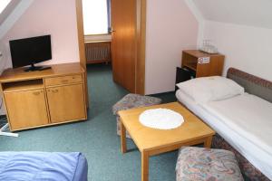 a small room with a bed and a table at Pension - Alt - Strassgang in Graz