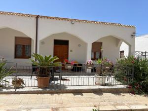 a white house with a table and some plants at Villa Dolce Vita rooms in Castelluzzo