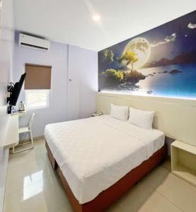 メダンにあるLexus Hotel Medanのベッドと壁に絵が飾られた寝室