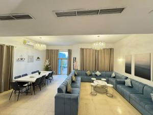 a living room with a blue couch and a table at سافانا امواج Amwaj savana in Half Moon Bay