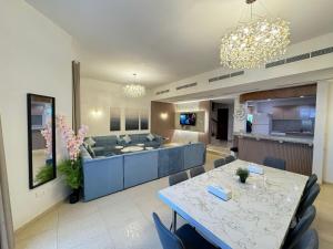 a living room with a table and a couch at سافانا امواج Amwaj savana in Half Moon Bay
