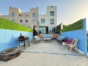 a patio with chairs and a grill in front of a building at سافانا امواج Amwaj savana in Half Moon Bay
