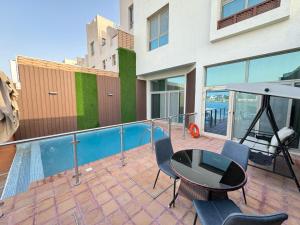 a patio with a table and chairs on a balcony at سافانا امواج Amwaj savana in Half Moon Bay