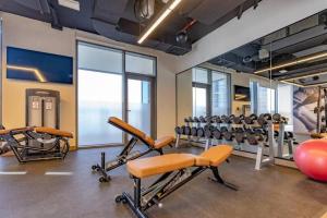 een fitnessruimte met diverse fitnessapparatuur in een kamer bij CitiHome-2BR creek harbour island in Dubai