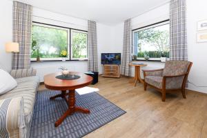 uma sala de estar com um sofá e uma mesa em Ferienwohnung AnneHuus em Bensersiel