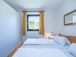 1 dormitorio con 2 camas y ventana en Pühler - Ferienwohnung Möwe en Kronsgaard