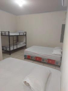 a room with two beds and a shelf with towels at Rancho do allan in Três Marias +33 photos