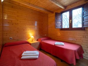 um quarto com 2 camas num chalé de madeira em Centro de Vacaciones Morillo de Tou - Ainsa em Aínsa