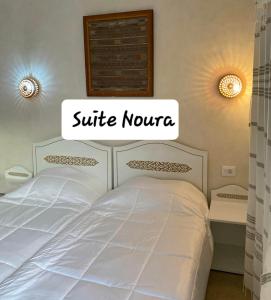 ein weißes Bett mit einem Schild, das die Suite Kunta liest in der Unterkunft Djerba rêve vacances Noura in Midoun
