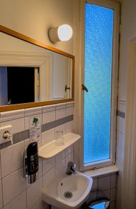 a bathroom with a sink and a window at Hotel-Maison Am Olivaer Platz in Berlin