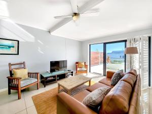 una sala de estar con un sofá y una mesa en AZURE 31 ON BIG BAY, en Big Bay
